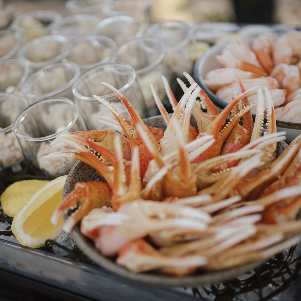 A seafood bar with crab claws, shrimp, and lemon wedges