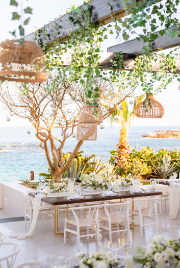 A beautifully arranged coastal wedding ceremony setup with ocean views and elegant floral décor