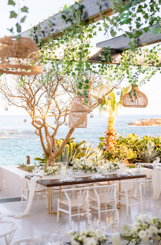 Luxurious beach wedding setup with elegant floral arrangements, soft lighting, and a breathtaking ocean backdrop