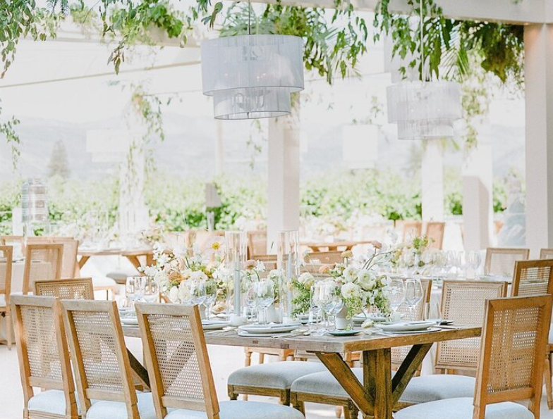 Stylish welcome party décor with string lights, floral arrangements, and cozy seating.