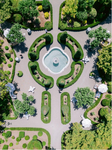 an aerial view of a unique wedding venue with a garden, a fountain, and assured privacy.