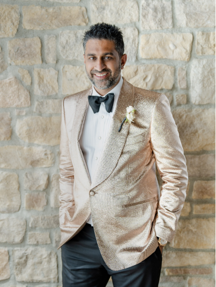 An image of a groom wearing a suit with a bow tie