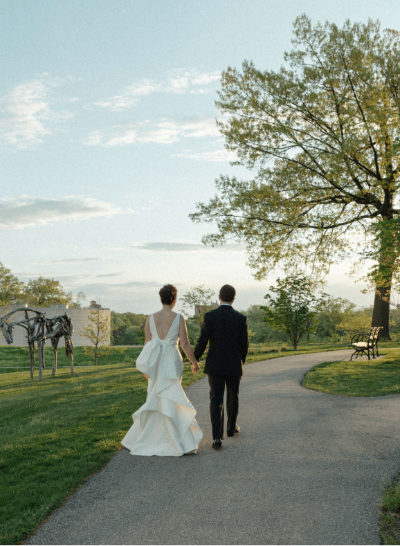 Bride and groom walking hand in hand along a scenic garden path during their Chicago wedding.