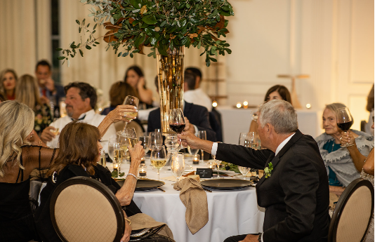 Guests raising glasses at an indoor wedding reception with elegant table decor