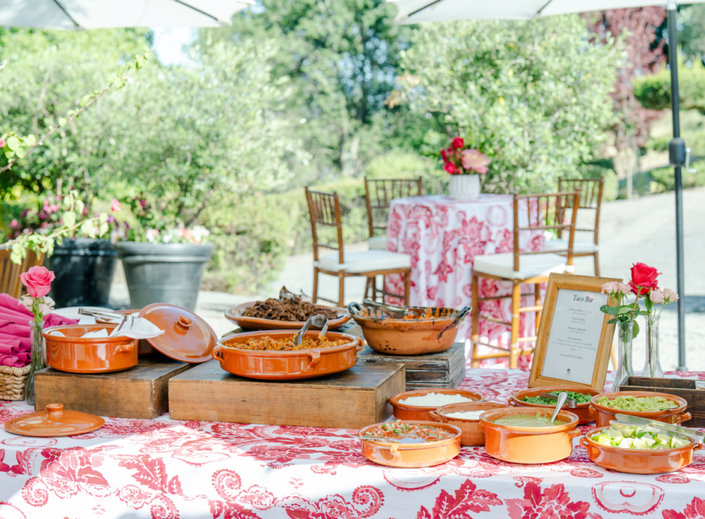 Outdoor wedding taco bar with traditional dishes and toppings in terracotta bowls