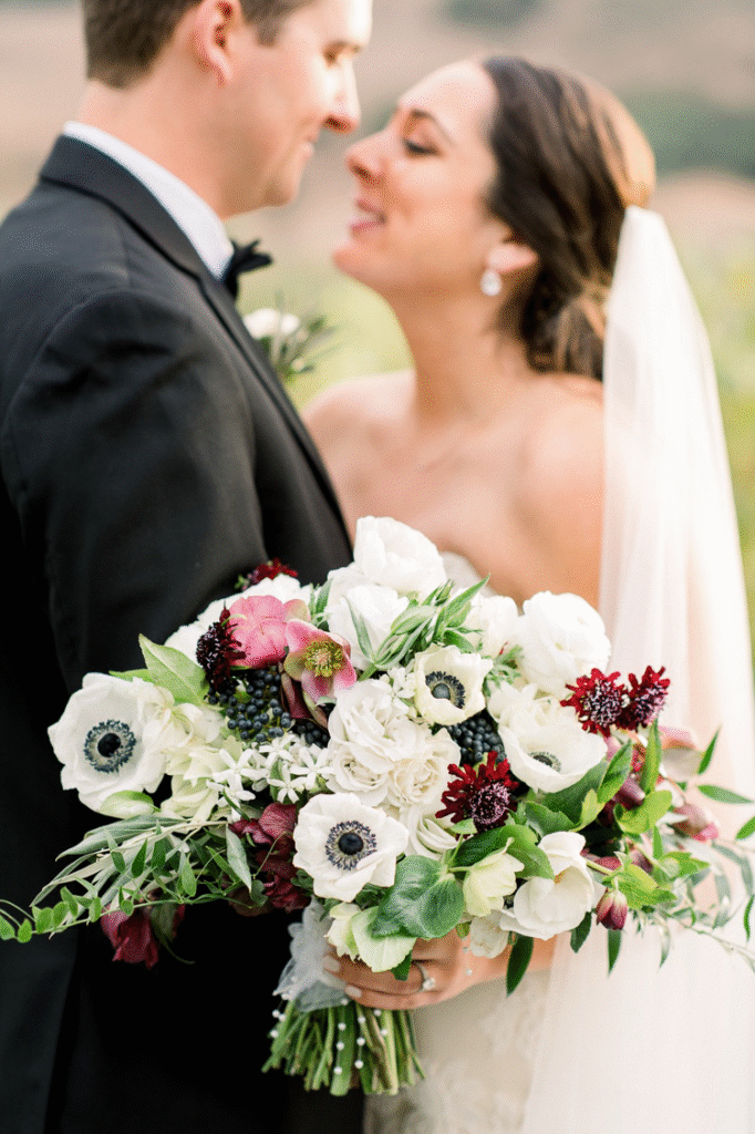a bride and groom standing together holding a bouquet