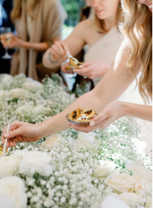 An image of guests enjoying bridal shower desserts at an elegant event