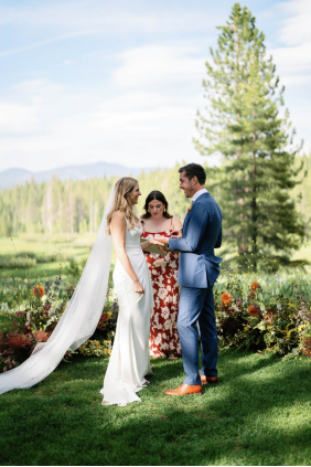 a bride and groom standing outdoors in a botanical setting