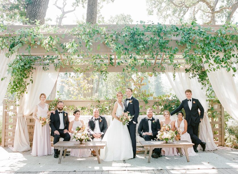 A couple posing with their family at their wedding.