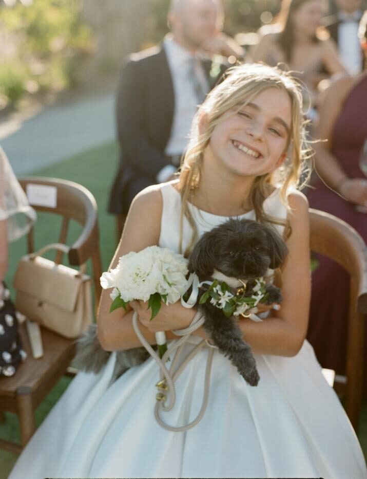 a girl with blonde hair holding a puppy.