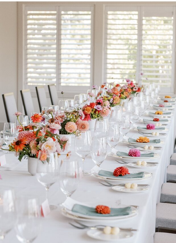 Long wedding reception table with floral centerpieces