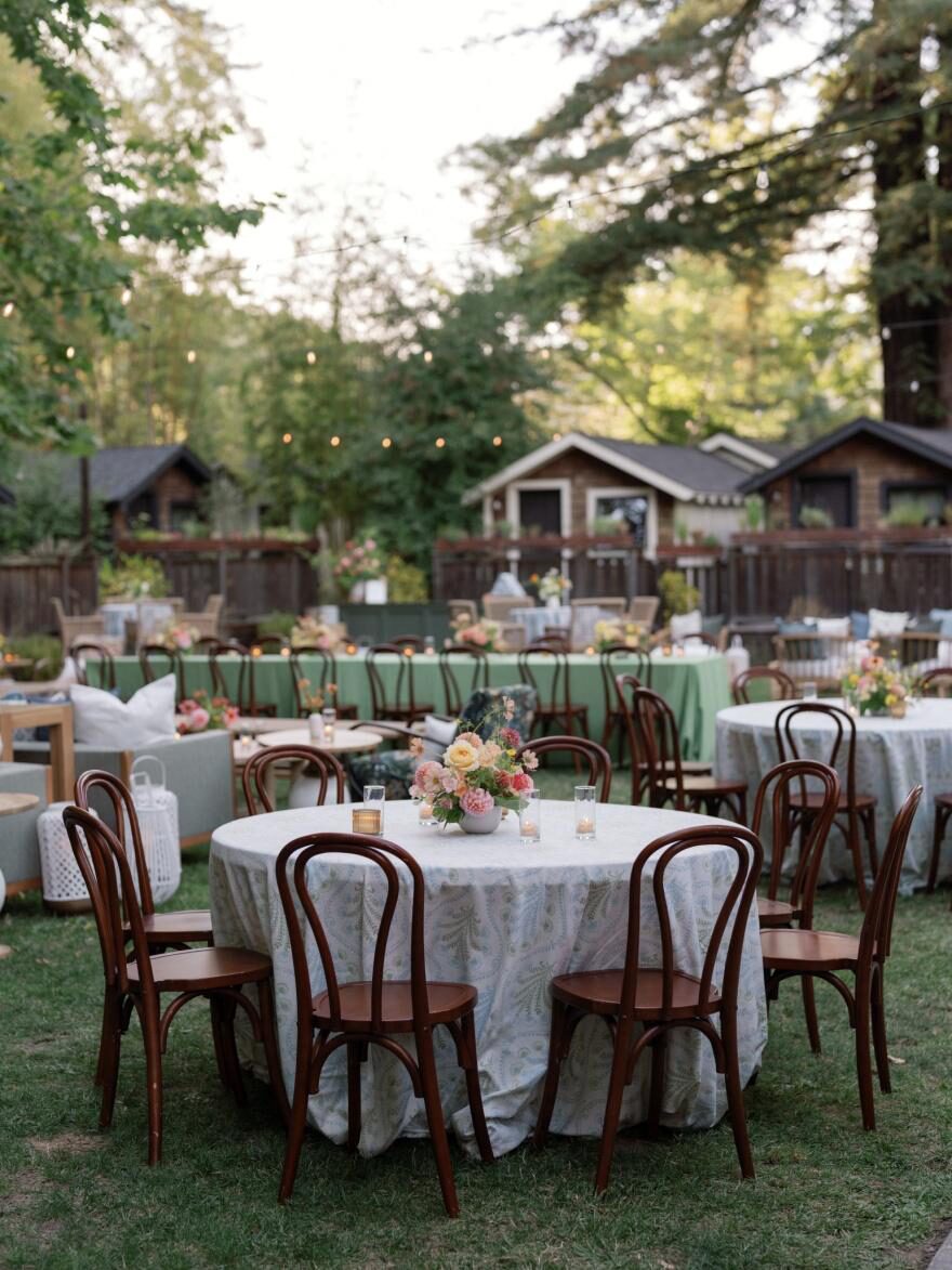 an outdoor wedding venue with wooden chairs.