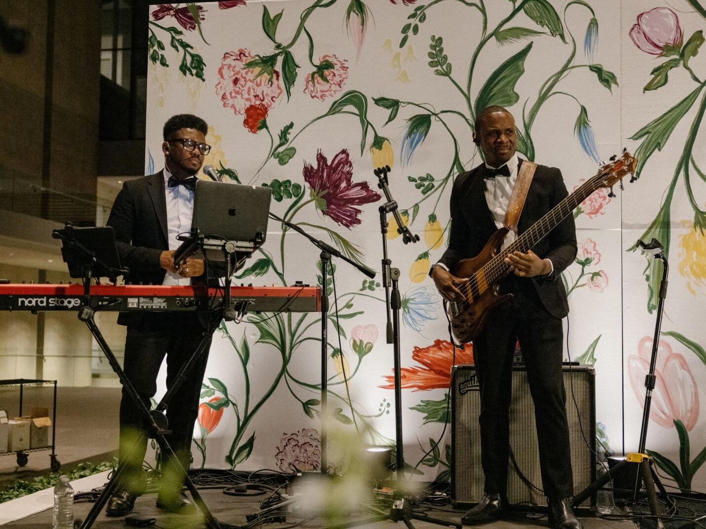 Two male musicians, dressed in tuxedos and bow ties, perform on stage.