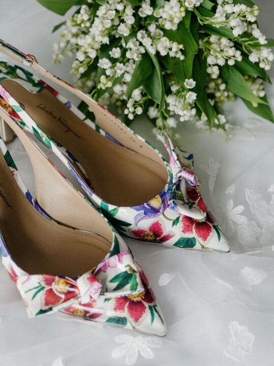 An image of white flowers and colourful shoes on a white surface
