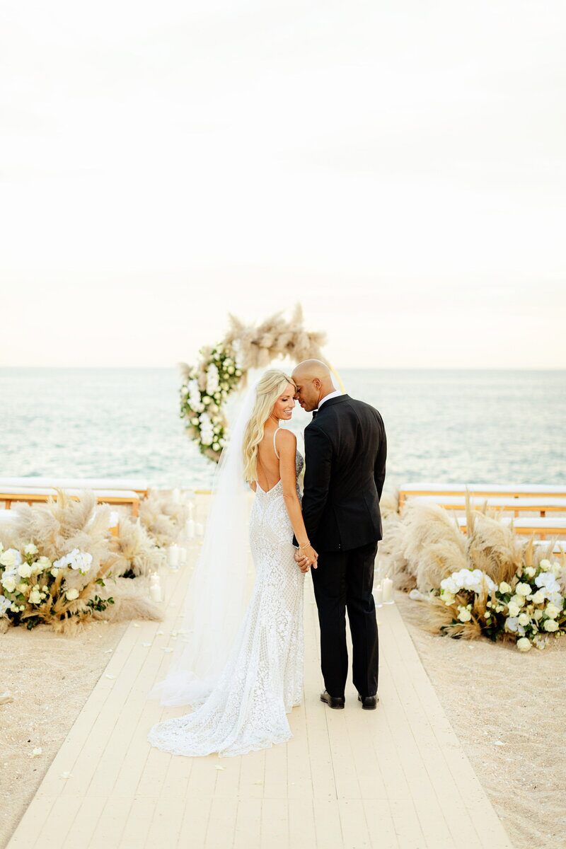 A beautiful beachfront wedding with a couple looking at each other.