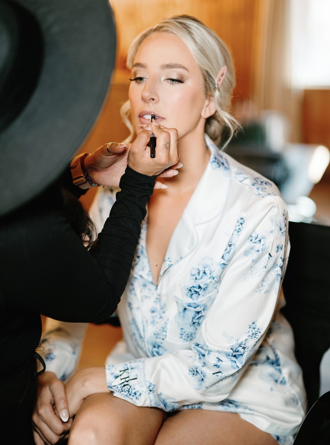 A bride is getting her makeup done by a professional