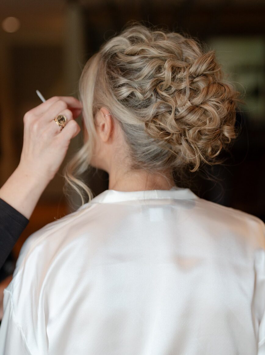 Woman getting her makeup done from a beauty artist with styled hair