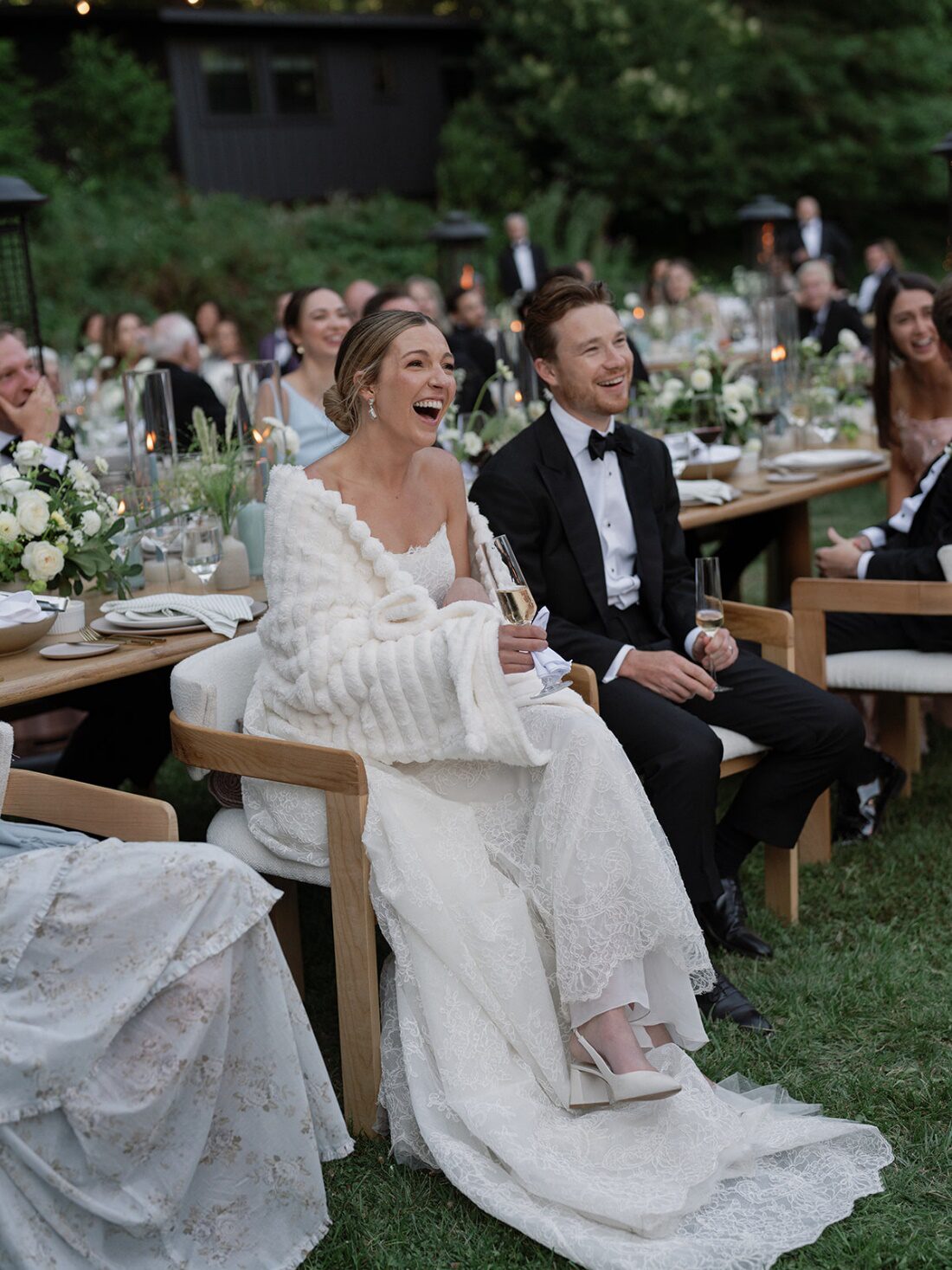 Bride, groom, and other wedding guests smiling during a delightful wedding speech