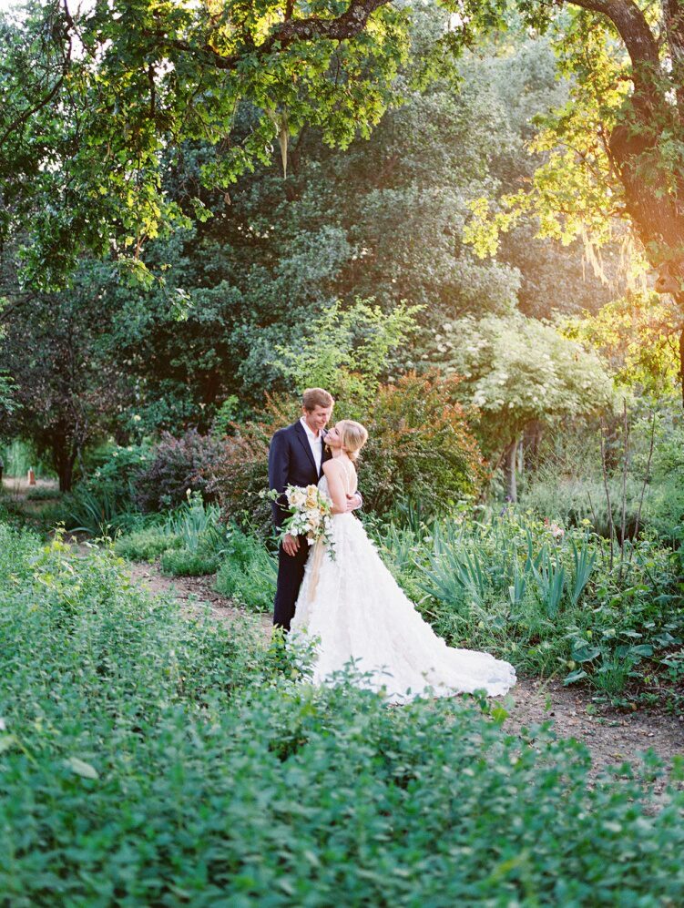 a bride and groom standing outdoors.