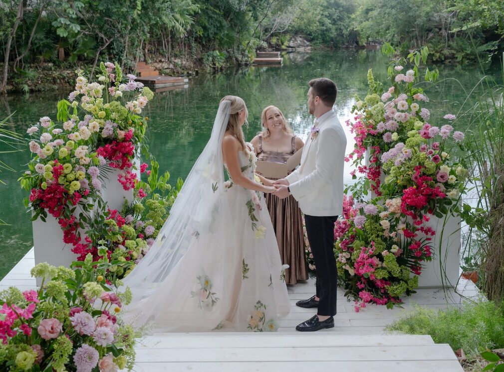 A flower arch behind a couple getting married