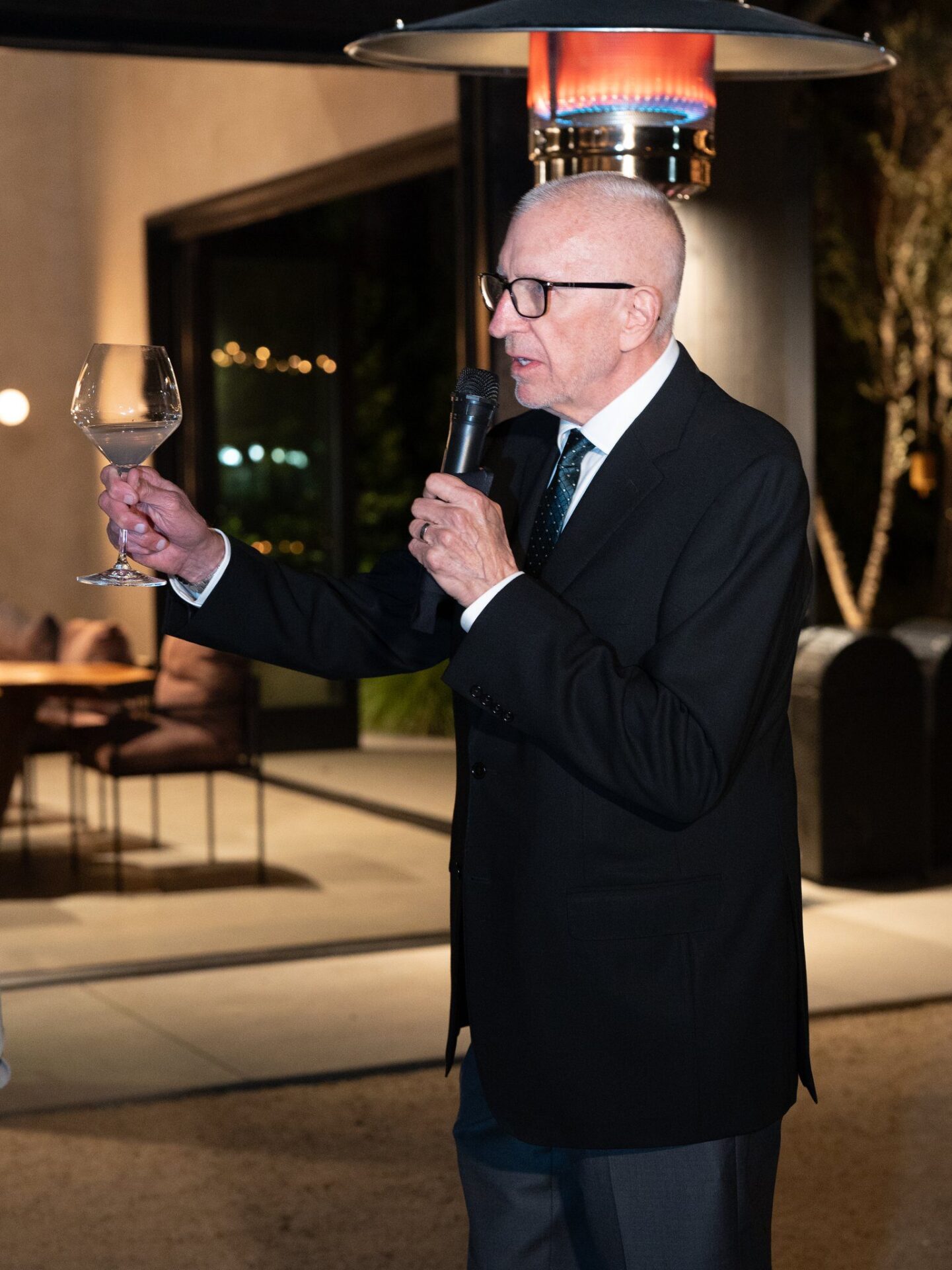 A wedding guest giving a speech with a glass in his hand
